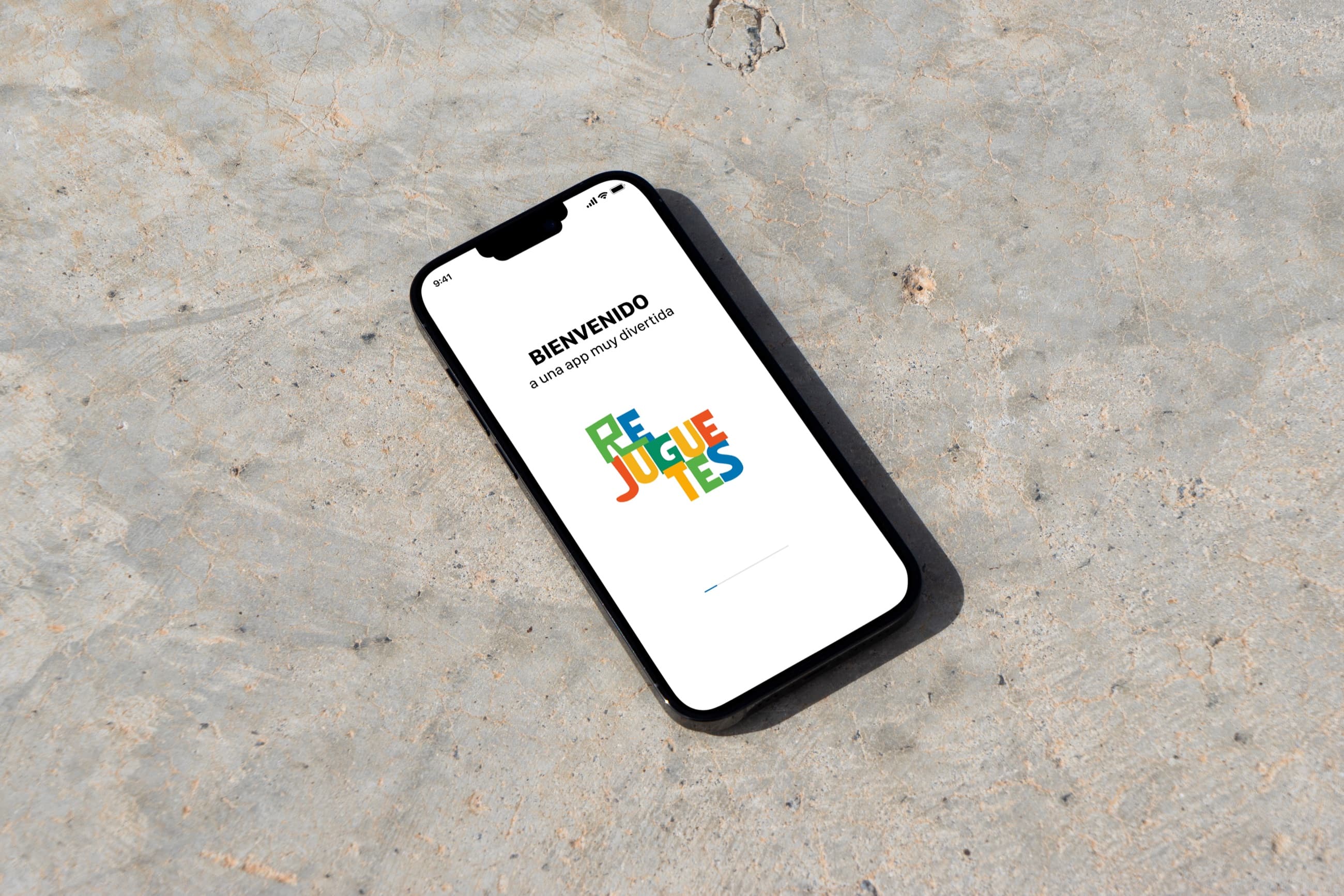 Celular apoyado sobre cemento con la pantalla de bienvenida de ReJuguetes