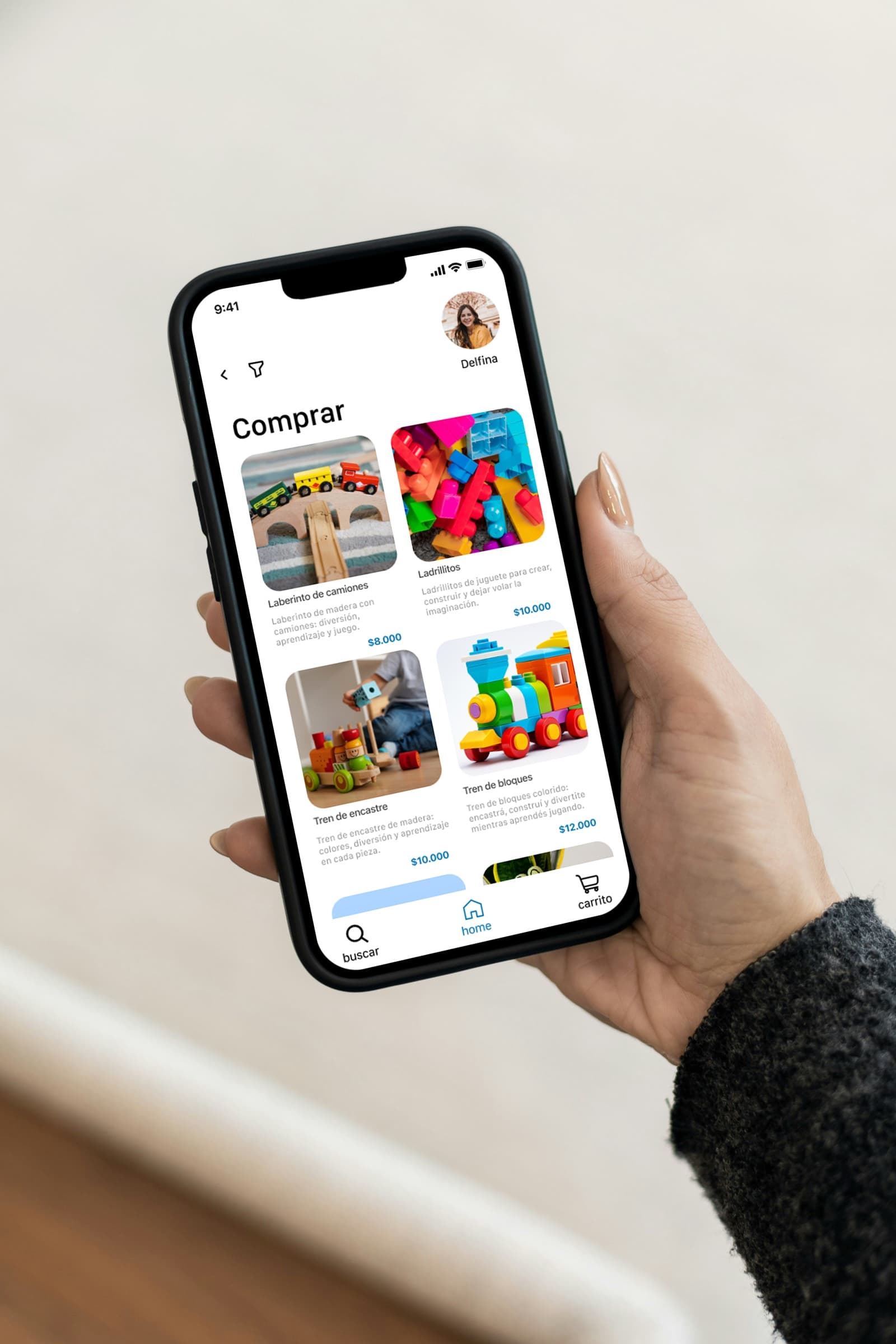 Mano sosteniendo un celular con la pantalla «Comprar» de ReJuguetes